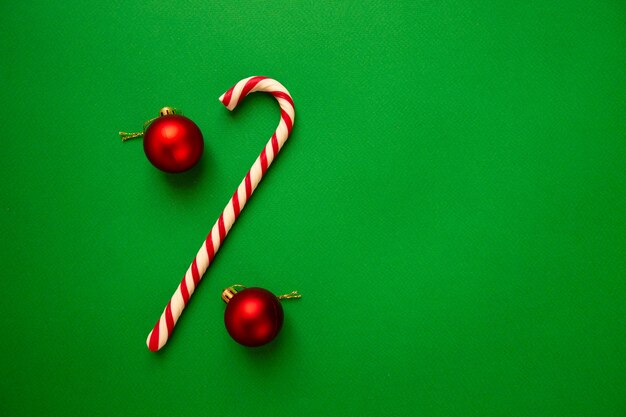 Christmas tree balls and striped candy on green