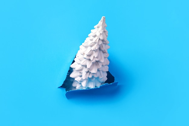 Christmas tree on a blue surface, minimalist concept