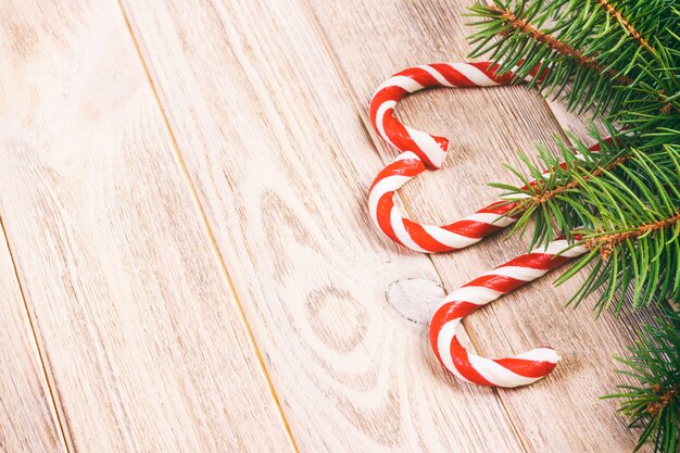 Foto ramo e bastoncino di zucchero dell'albero di natale su una tavola o su un bordo di legno per. tema del nuovo anno. spazio per il testo. tonica