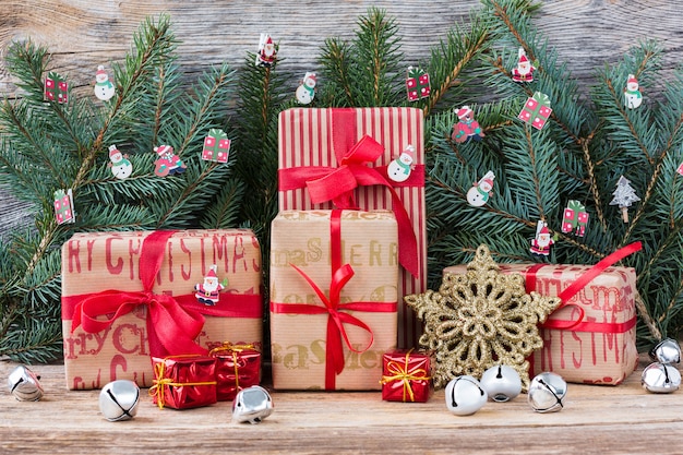 Christmas tree branch and gifts on wooden background. Copy space