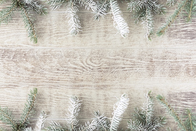 Ветвь рождественской елки с шишками на деревенском деревянном столе. Зимний фон с копией пространства. Вид сверху. Плоская планировка