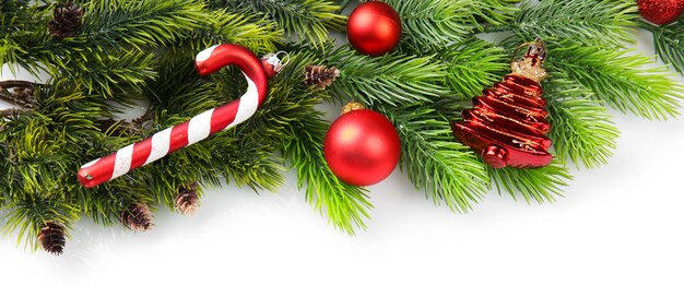 christmas tree branch with red berries and decorations on white background