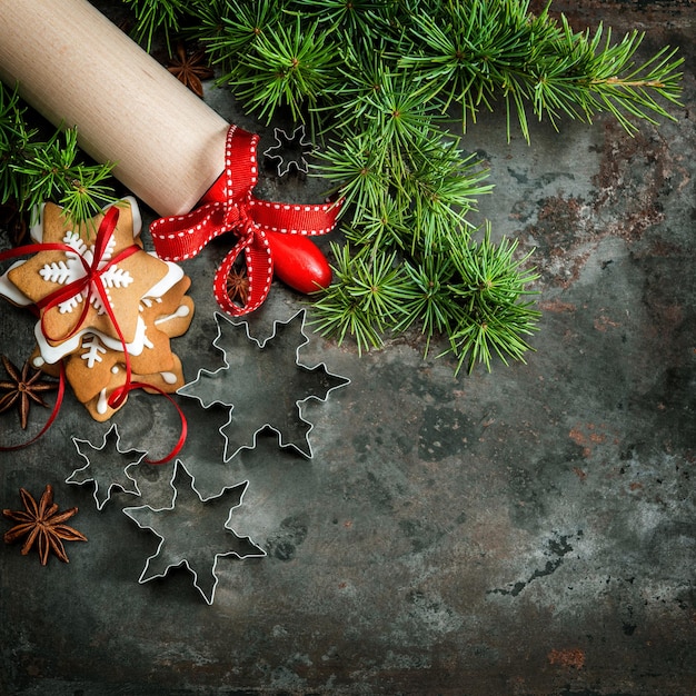 クリスマスツリーの枝、クッキー、ベーキングツール。休日の背景。ヴィンテージスタイルのトーンの写真