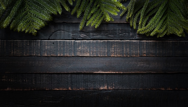 Christmas tree branches on dark wooden background  with copy space. Flat lay