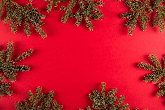 Christmas tree branches in the form of a frame on a red , Christmas , greeting card copyspace.