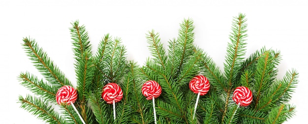 Foto rami di albero di natale e lolipop rosso come decorazione.