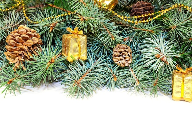 白い背景のクリスマスツリーの枝と円<unk>の贈り物とおもちゃ