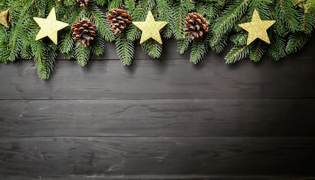 Christmas tree branches with fircones gold stars on dark wooden background