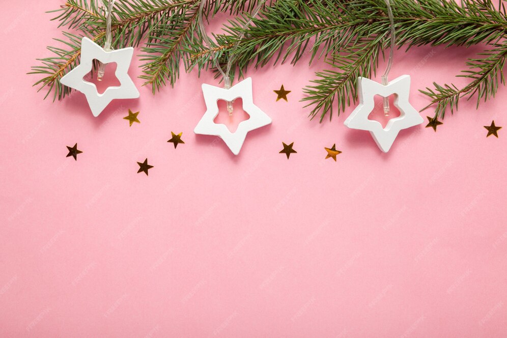 Premium Photo | Christmas tree branches with a garland on a pink