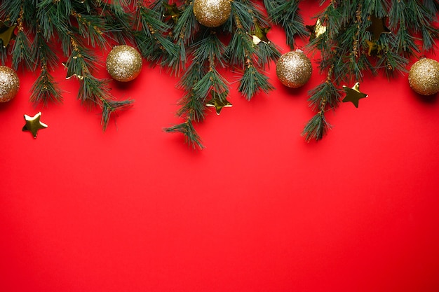 Christmas Tree Branches with toys on red with copyspace