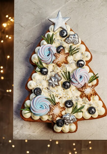 Torta dell'albero di natale. dolce regalo festivo, decorazioni con luci di capodanno.