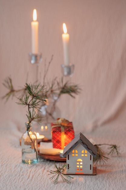 Christmas tree and a candlestick in the form of a house a cozy
miniature layout of the house decorations for christmas with
candles