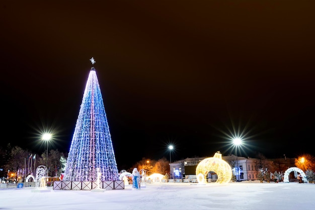 クリスマス ツリー クリスマス ボール サンタ クロースと雪に覆われた街の中央広場に雪の乙女