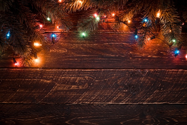 Christmas tree and colorful lights bulb. Merry christmas (xmas) background. Old wood texture - vintage styles