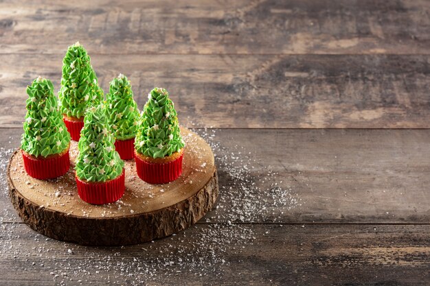 Christmas tree cupcakes on wooden table