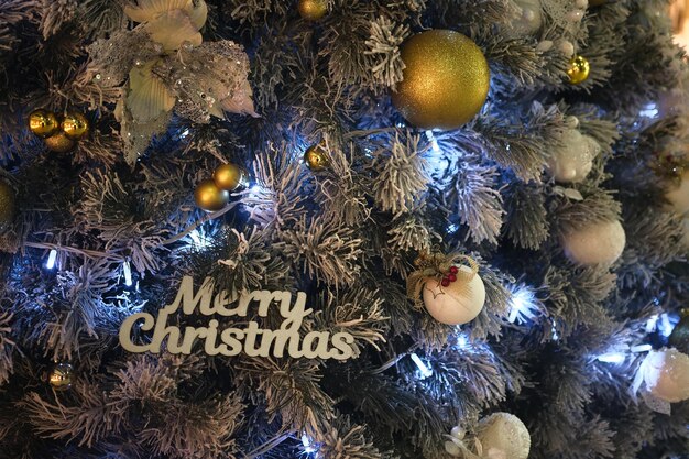 Рождественская елка и декор с деревянными словами, синими огнями и цветными шариками