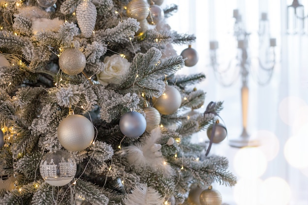 Albero di natale decorato in stile retrò con coni di natale con piume bianche argento e palline blu