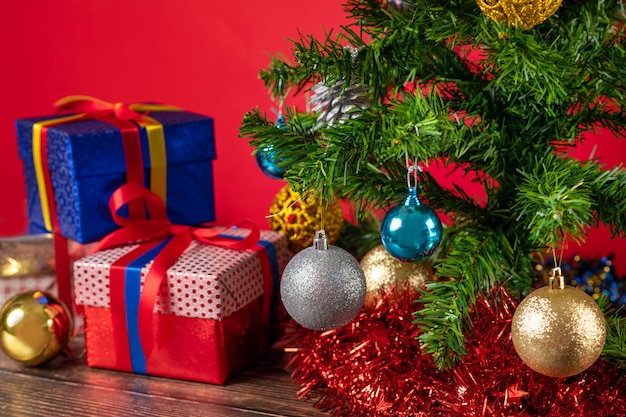 明るいクリスマスボールで飾られたクリスマスツリー。その下には多くの明るい贈り物があります。