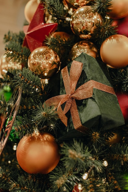 クリスマスボールで飾られたクリスマスツリー赤い星黄金のお祝いの時計とベルベットのギフトボックス