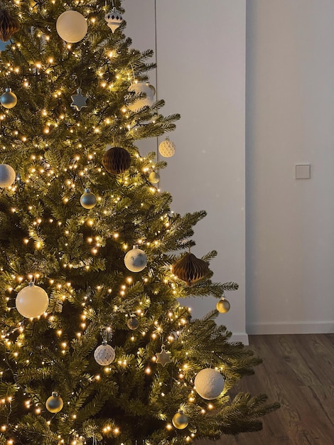 Christmas tree decorated with glowing garland lights baubles