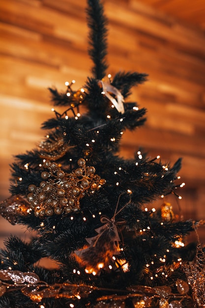 Christmas tree decorated with a golden garlands light New Year composition in a festive interior