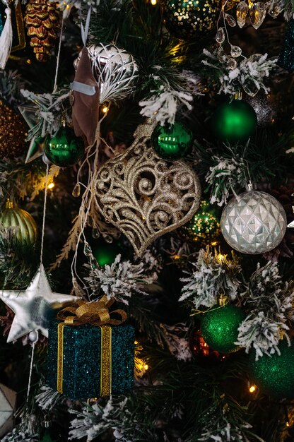 Christmas tree decorated with green silver and brown toys closeup