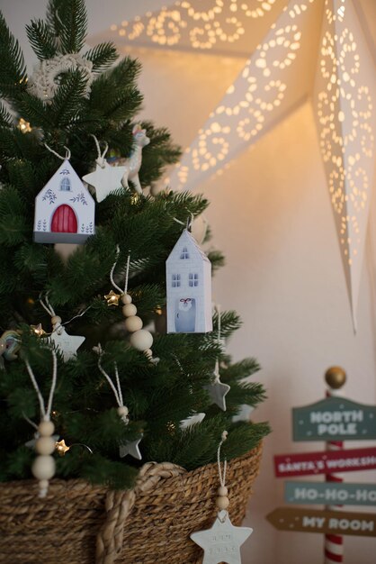 Christmas tree decorated with toys and garlands in the form of houses