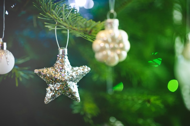 Decorazione dell'albero di natale con stella d'argento e luci di natale sfocate