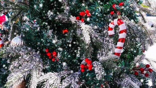 写真 白い雪の赤と白の杖のクリスマス ツリーの装飾メリー クリスマスとハッピー ホリデー グリーティング カード フレーム バナー新年冬休日のテーマ