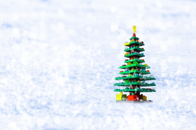 Рождественская елка из пластиковых блоков на белом снегу