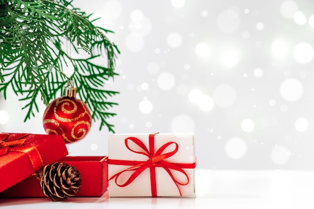Рождественская елка и подарочные коробки на светлом фоне. Праздничная открытка, место для текста.