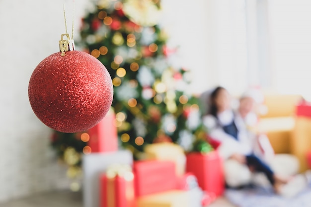 部屋の中に赤い装飾が施された緑のクリスマスツリー。