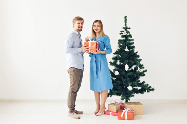 Christmas tree and holidays concept - Happy smiling family wearing santa hats celebrating at home.