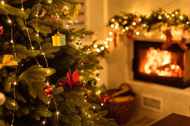 部屋のモダンな大理石の暖炉の近くにクリスマスツリーと家の休日の装飾。クリスマスツリーに焦点を当てる