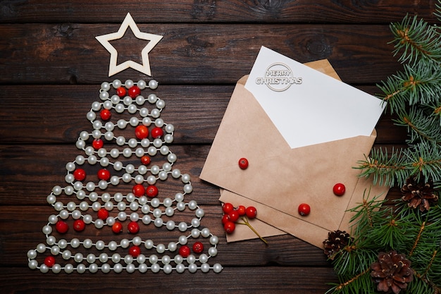 メリークリスマスの碑文と封筒にビーズと手紙で作られたクリスマスツリー