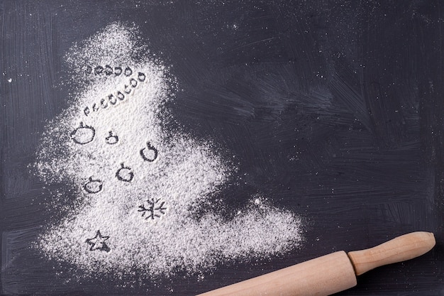 Christmas tree made of flour on black background space for text