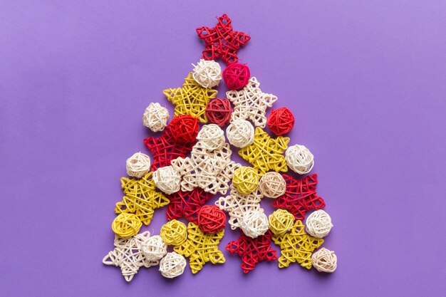 Christmas tree made from colored handmade ball decoration on colored background view from above new year minimal concept with copy space