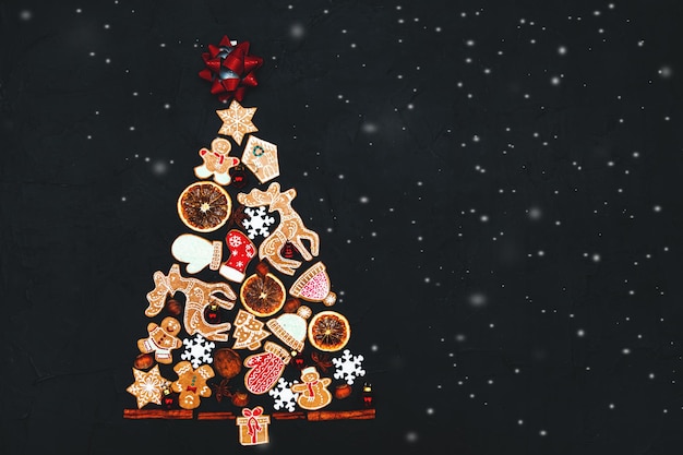 Новогодняя елка из пряников и специй на темном фоне. Скопируйте пространство. Новогодняя и рождественская открытка.