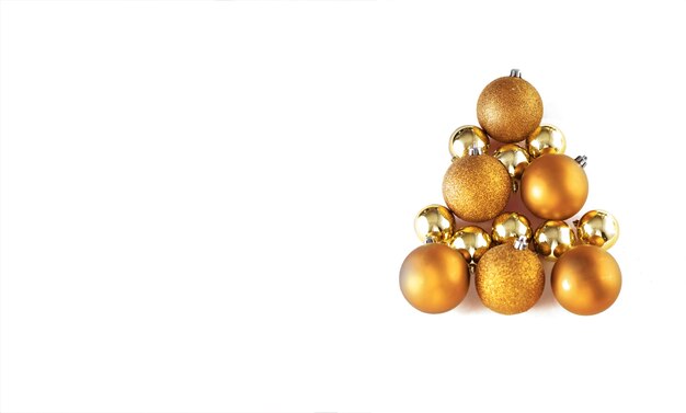 Christmas tree made of golden bauble decoration on white isolated background