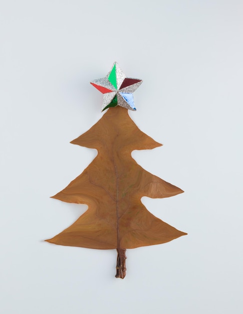 Рождественская елка из кленового листа на белом фоне Плоская планировка новогодняя природа минимальная концепция