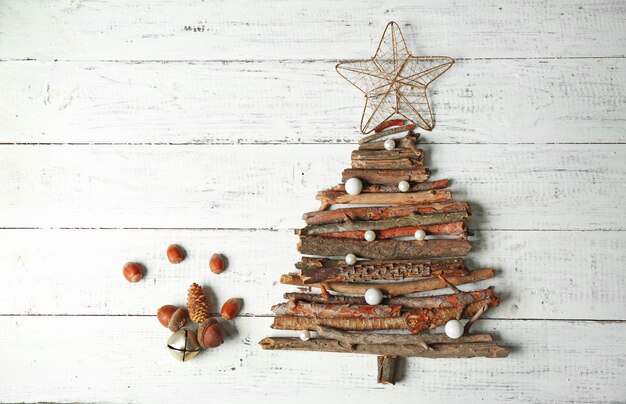 Christmas tree made of wooden branches on wooden table top view