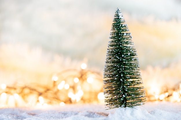 写真 贈り物と光のボケの背景と雪のクリスマスツリー
