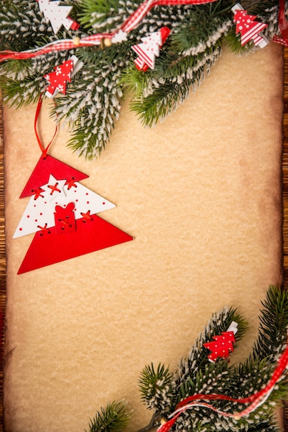 Фото Орнамент рождественской елки на винтажном пробеле бумажной карточки. рождественский праздник концепция