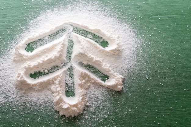 A Christmas tree painted from flour as from snow on a green background Christmas cooking flour Christmas tree