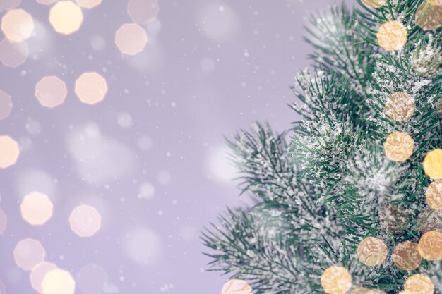 Christmas tree on a purple background with golden lights, copy space