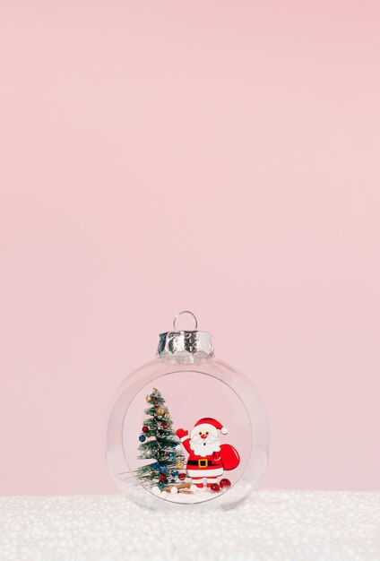 Christmas tree and Santa Claus inside of Christmas bauble on pink background Minimal winter idea