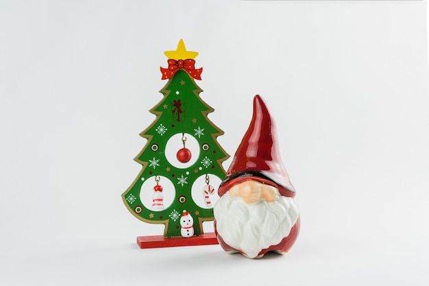 크리스마스 트리와 흰색 바탕에 장식이 있는 산타클로스. 크리스마스 장식입니다. 선택적 초점입니다.