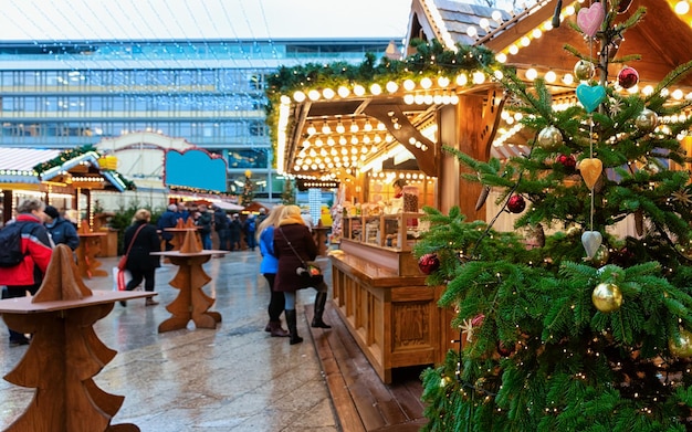 독일 겨울 베를린에 있는 카이저 빌헬름 기념 교회의 크리스마스 마켓에 있는 크리스마스 트리와 가판대. Advent Fair 장식 및 공예품이 있는 가판대 on Bazaar
