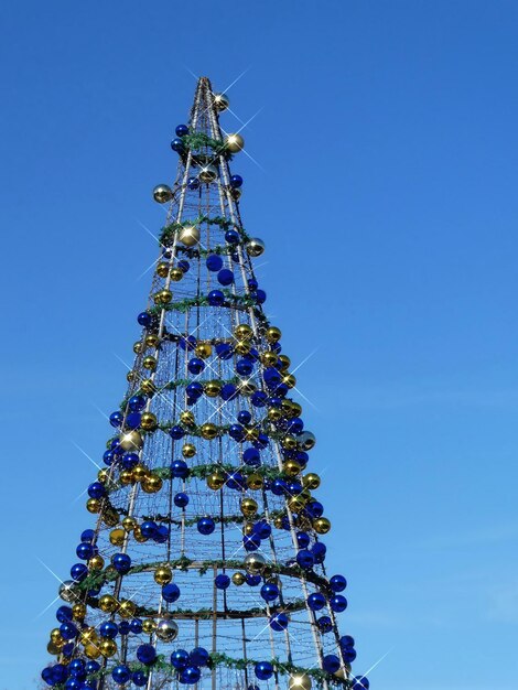 Christmas tree street decoration colorful balls blue sky background copy space