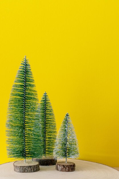 Christmas tree on table against yellow wall